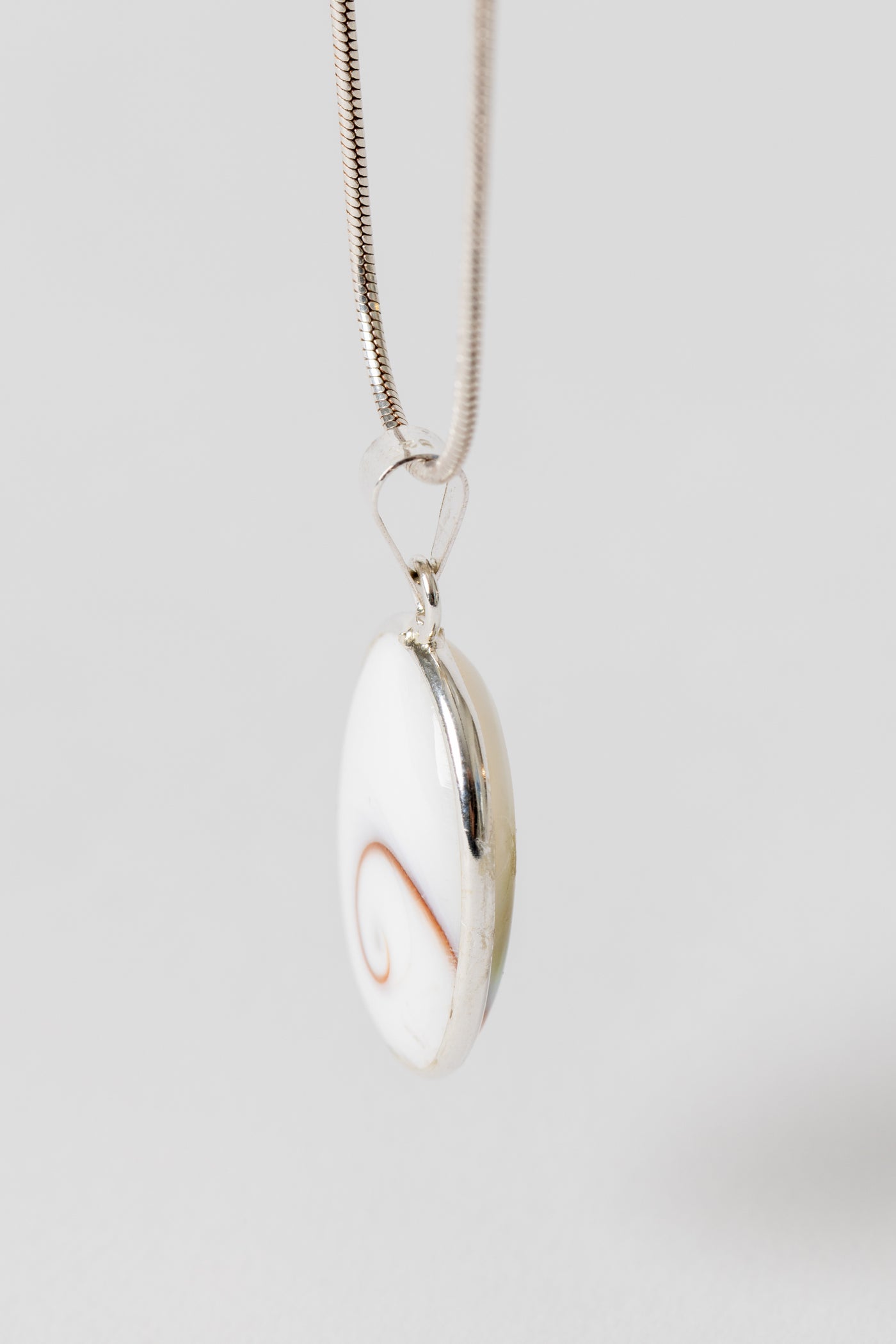 Sterling Shiva eye pendant with natural shell spiral pattern