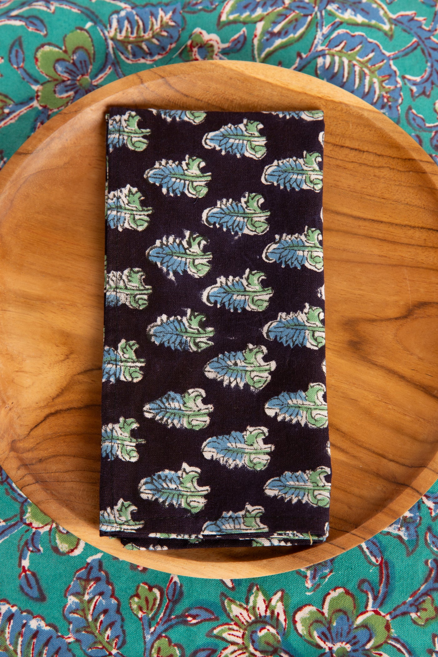 Black floral block print napkin on teak plate and block print placemat