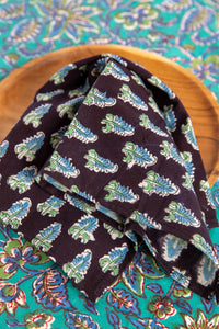 Black floral block print napkin on teak plate and block print placemat