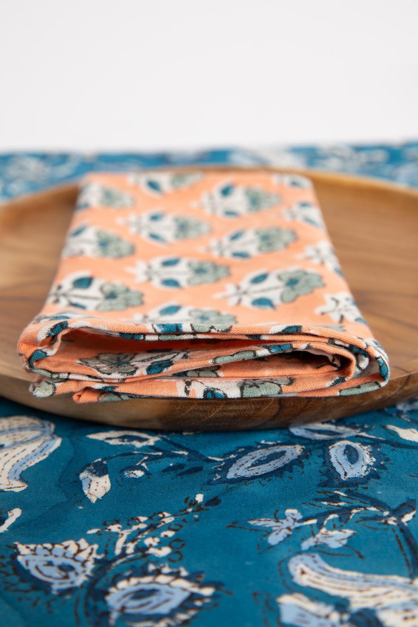 Dusty Coral floral block print napkin on teak plate and block print placemat