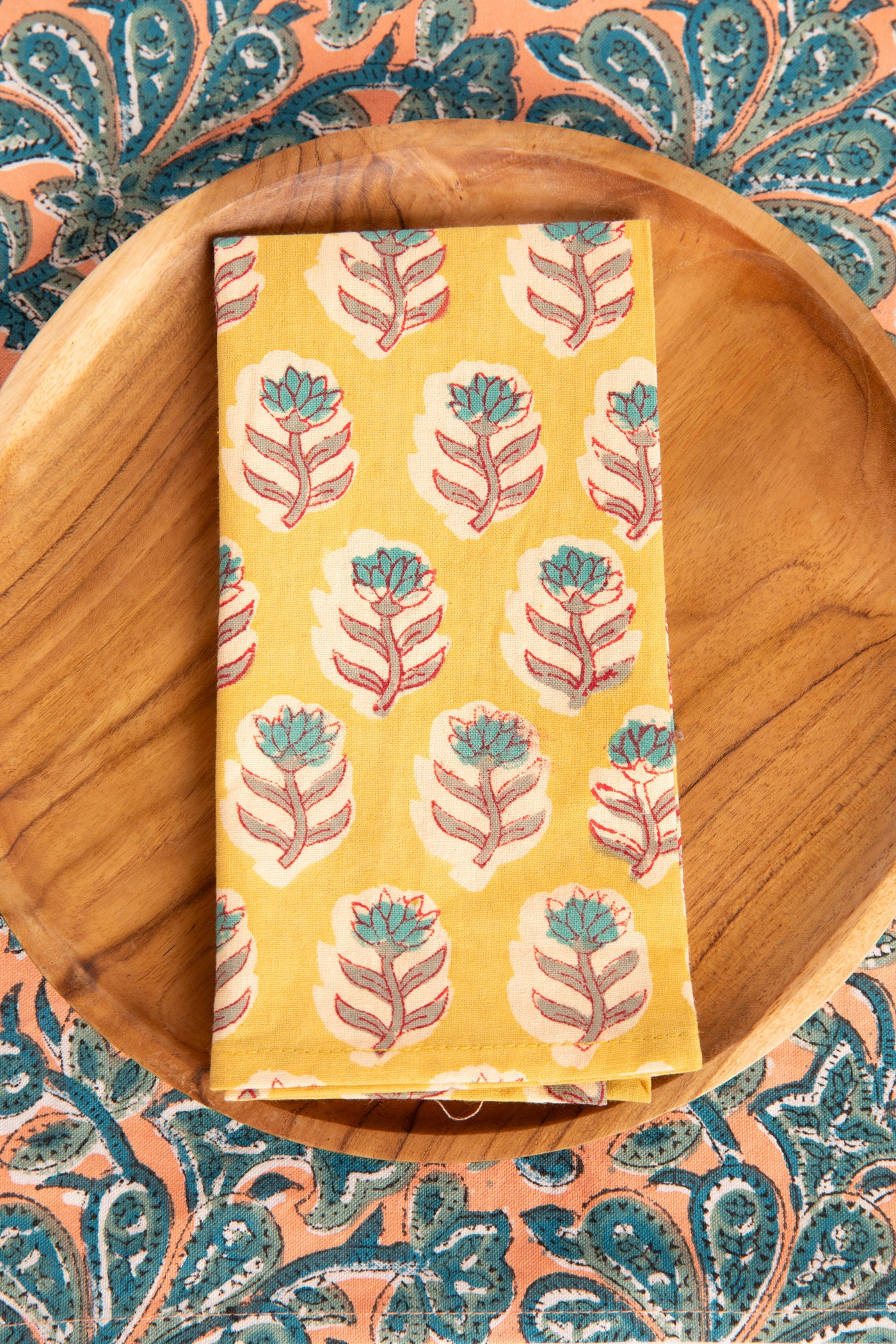Yellow Marigold floral block print napkin on teak plate and block print placemat
