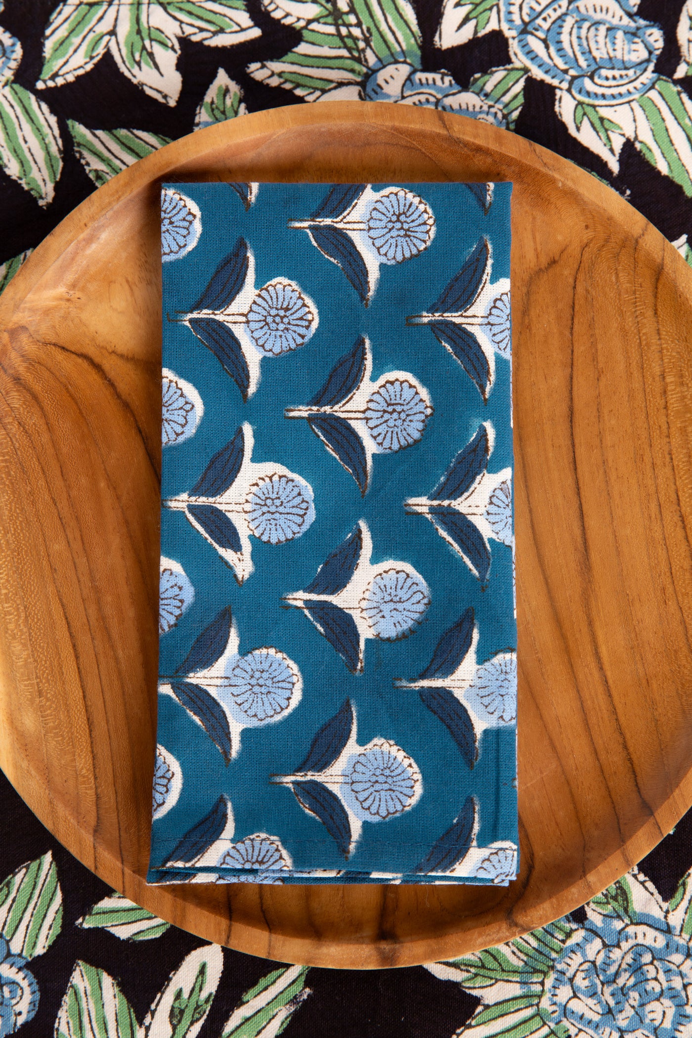 Storm Blue floral block print napkin on teak plate and block print placemat