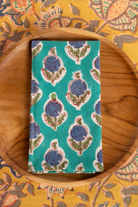 Turquoise block print napkin on teak plate and block print placemat