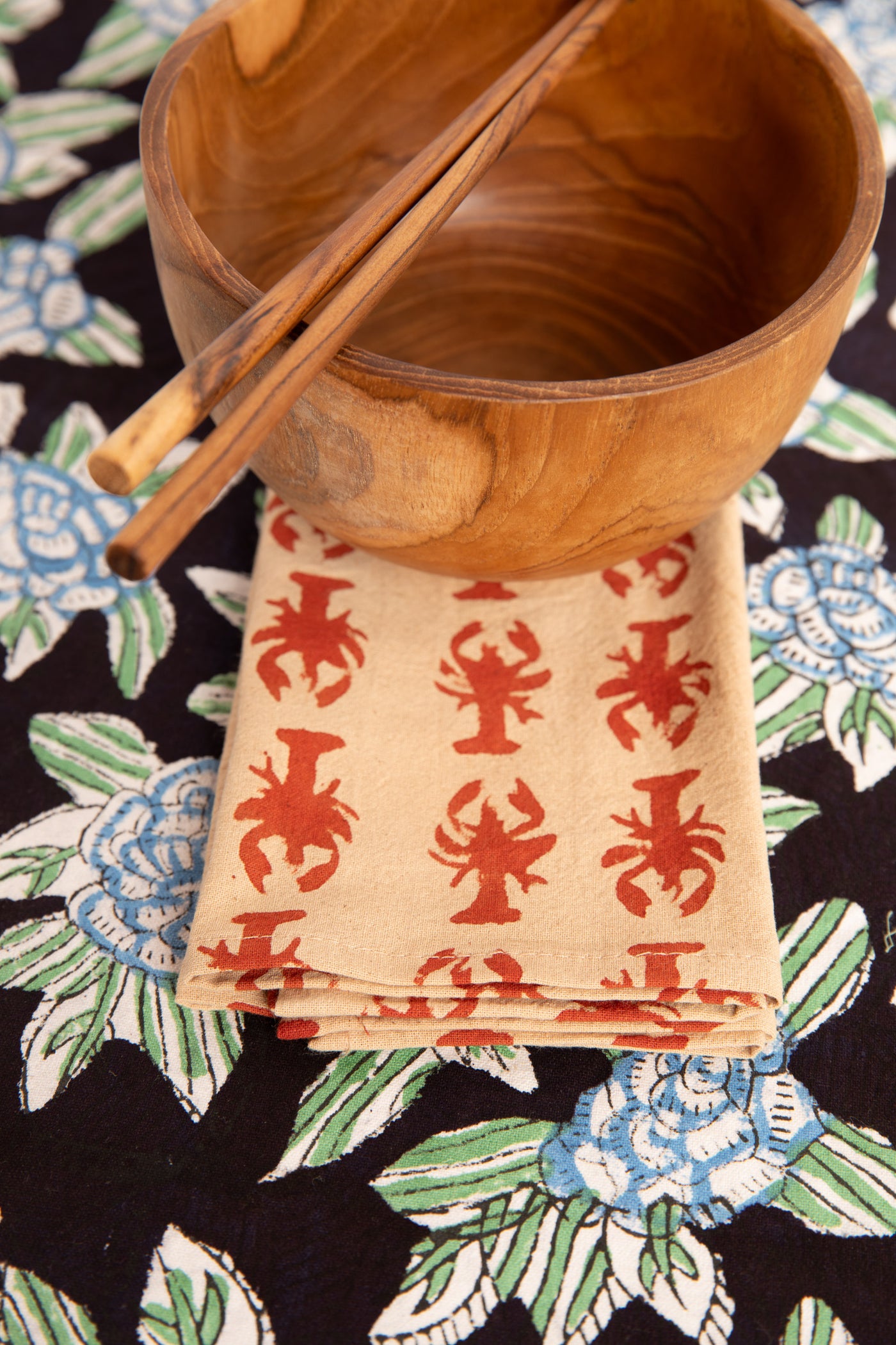 Red Lobster block print napkin under teak bowl and block print placemat