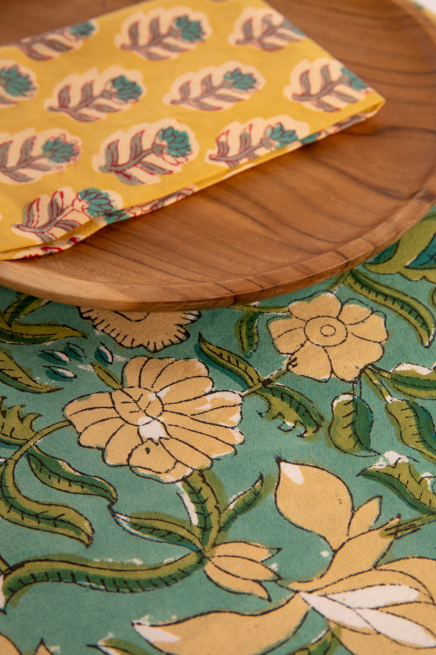 Aquamarine floral block print placemat under teak plate and block print napkin 