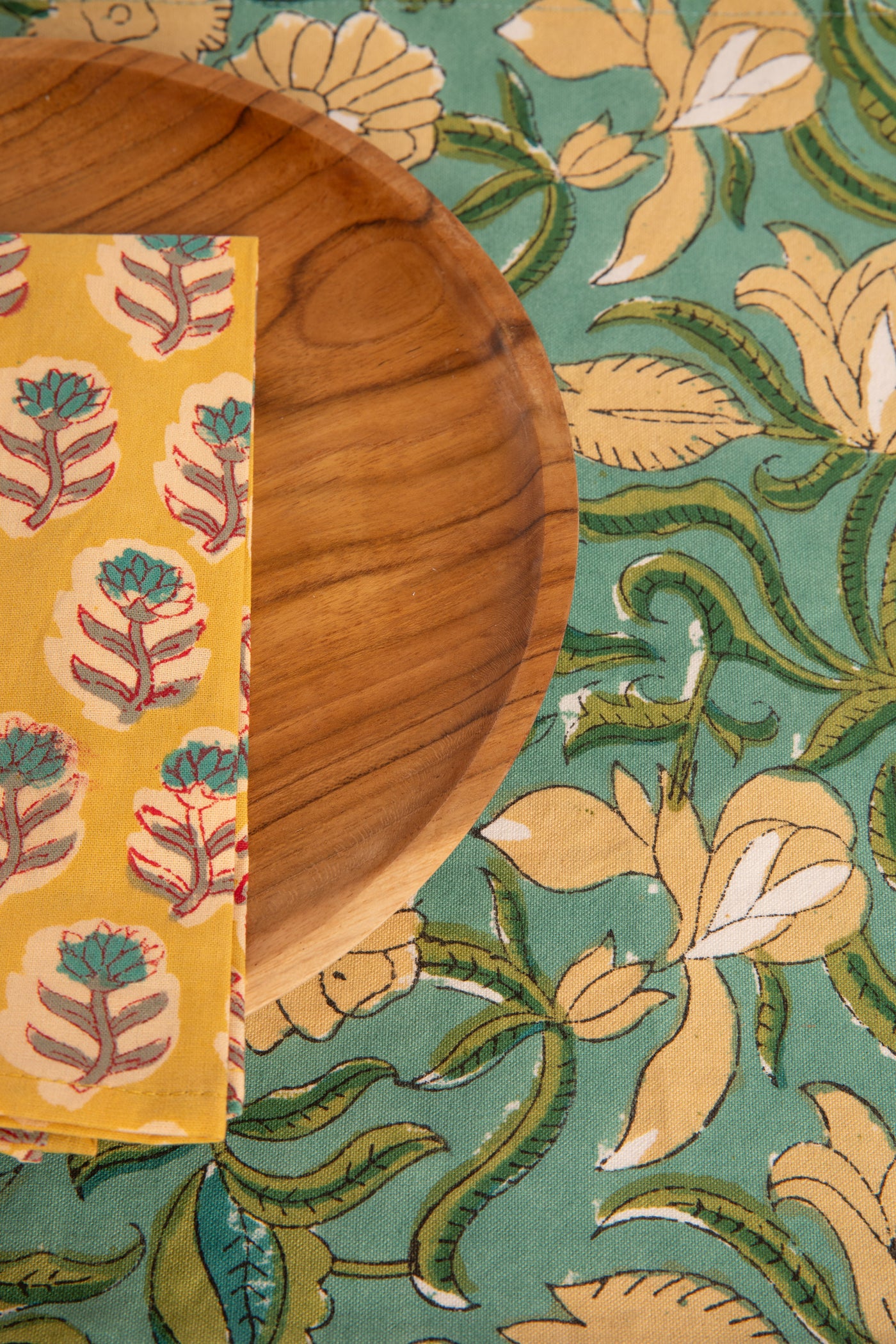 Aquamarine floral block print placemat under teak plate and block print napkin 