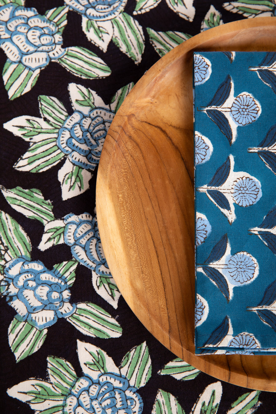 Black floral block print placemat under teak plate and block print napkin 