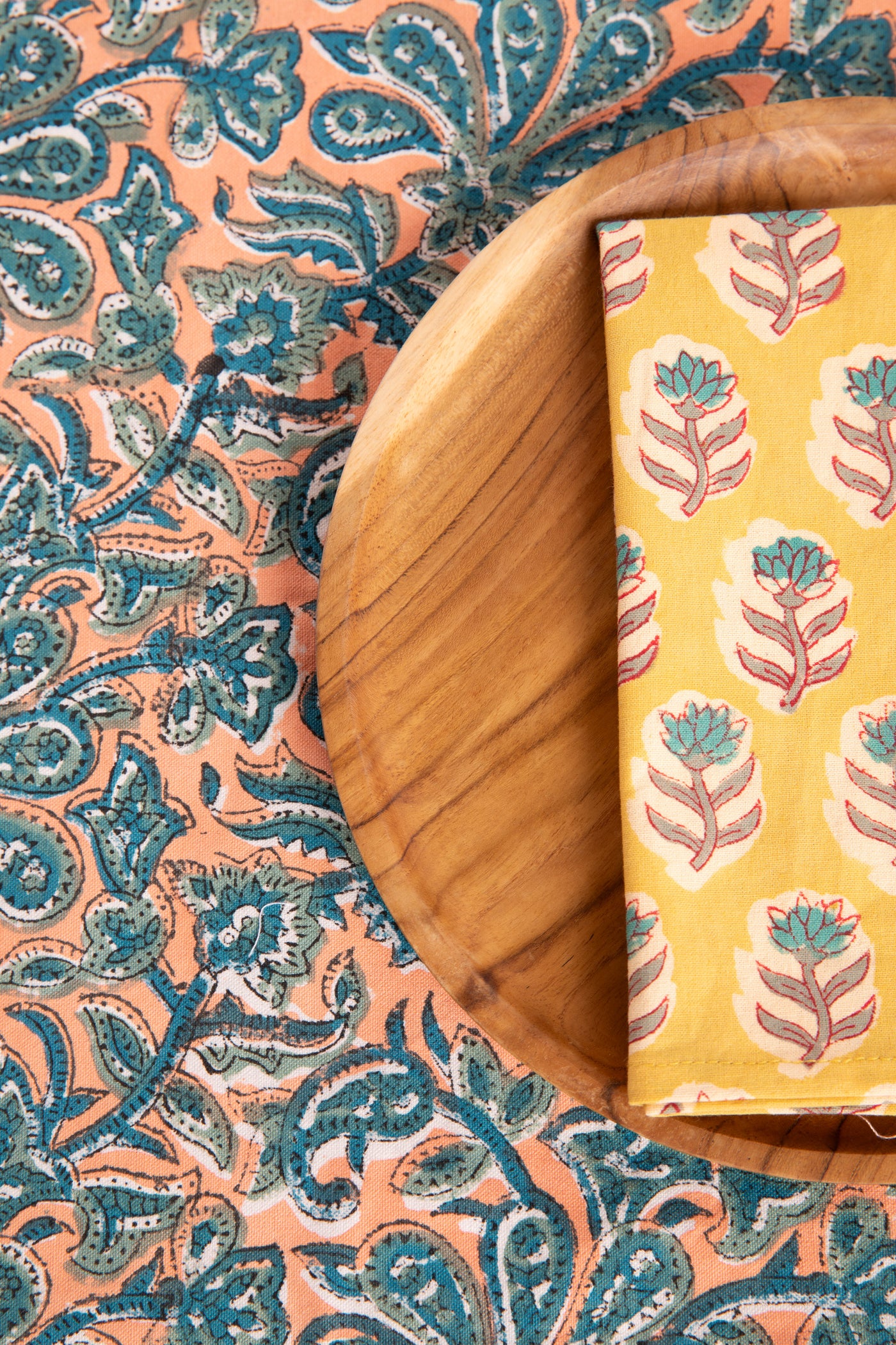 Dusty Coral floral block print placemat under teak plate and block print napkin 