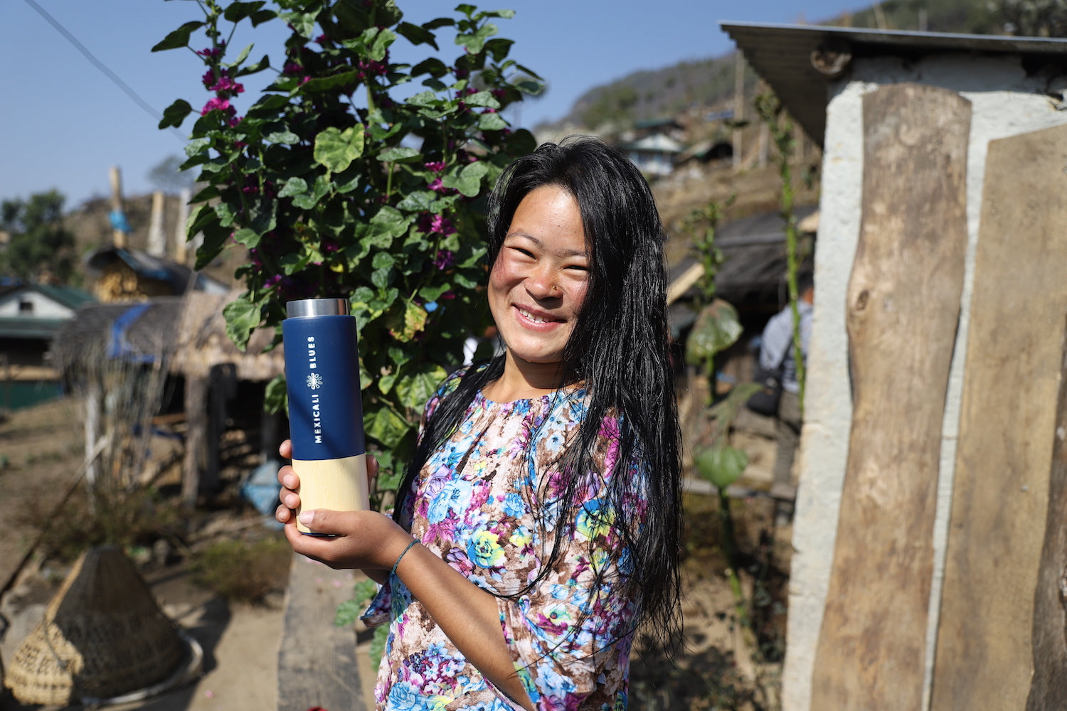 Smiling indigenous Nepalese woman high in the mountains with a Mexicali Blues water bottle recently filled by the new safe water drinking system installed in Bokchamsido, Nepal