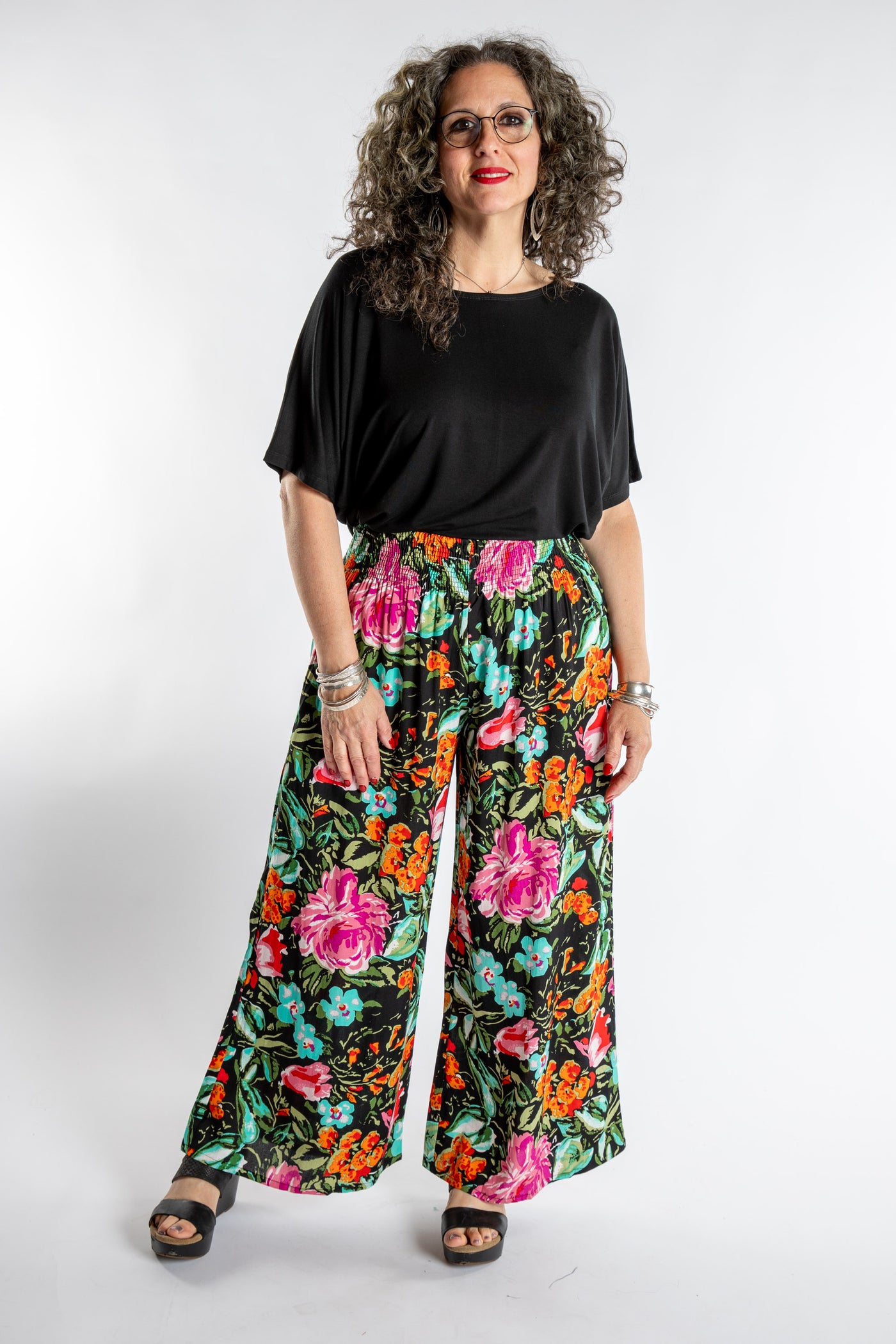Susan is wearing the Printed Penny Lane Pants in M/L in Navy Garden and the Allie Dolman in Black L/XL