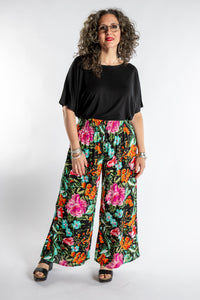 Susan is wearing the Printed Penny Lane Pants in M/L in Navy Garden and the Allie Dolman in Black L/XL