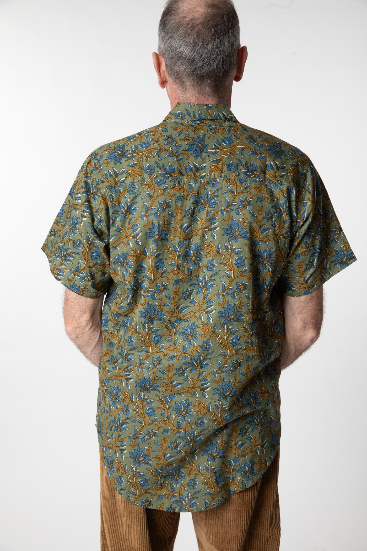 Chris, 5'7", wearing the LaLa Printed Cotton Button Up in Sage Floral, size M