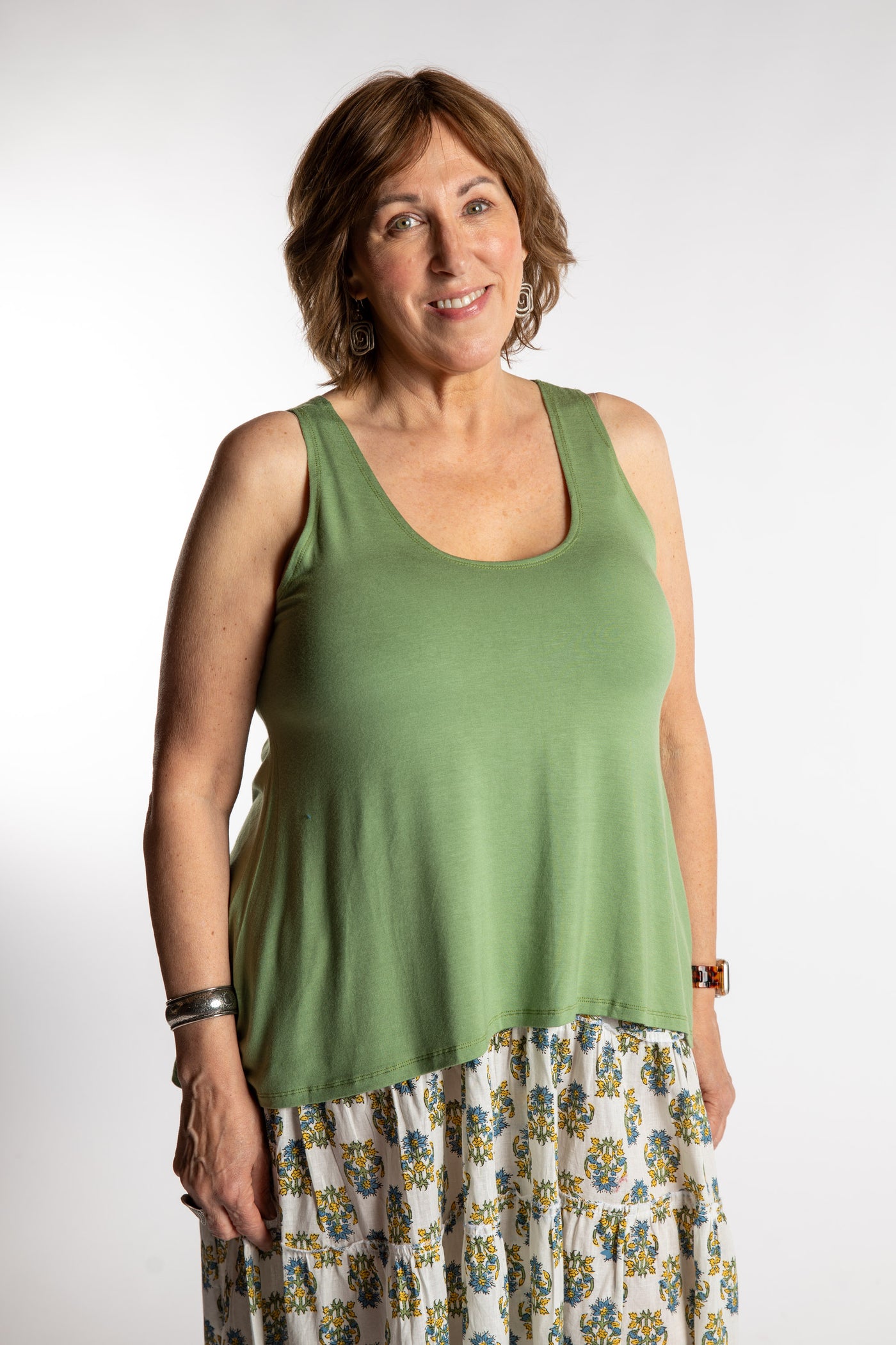 Betty is wearing the one size Ahana Flow Tank in Light Green