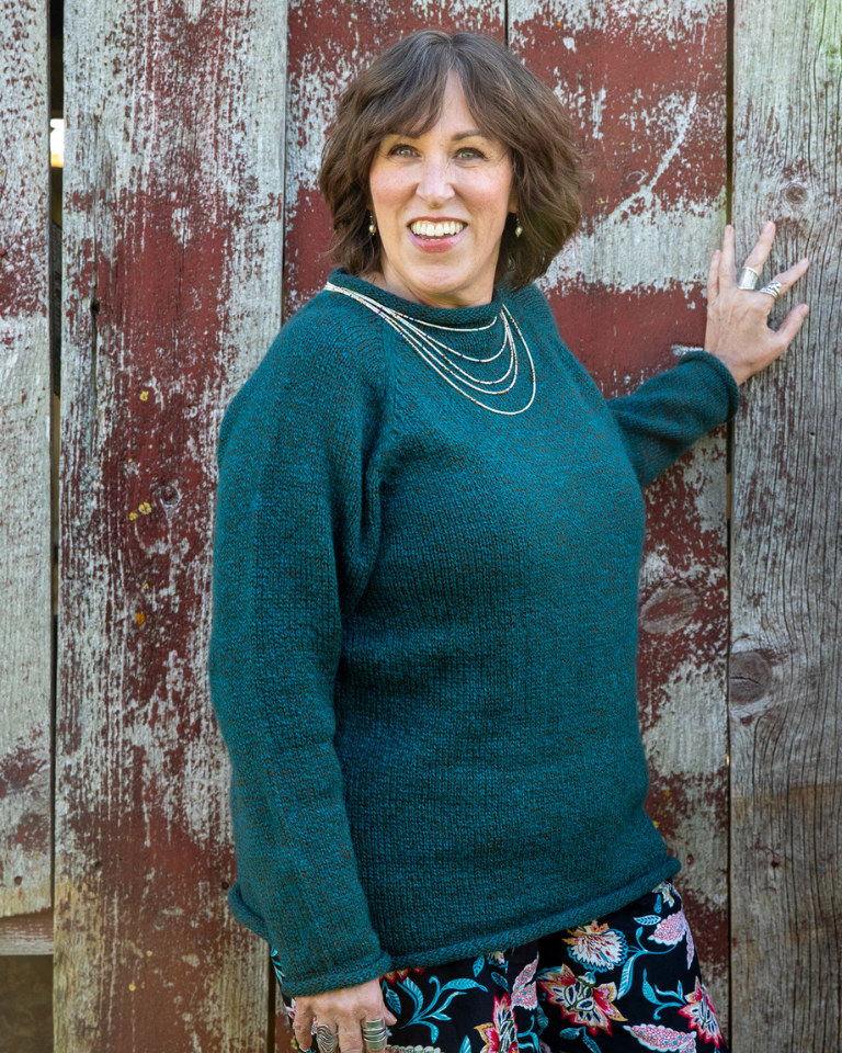 Betty wearing the L fisherman style roll neck alpaca sweater in Teal