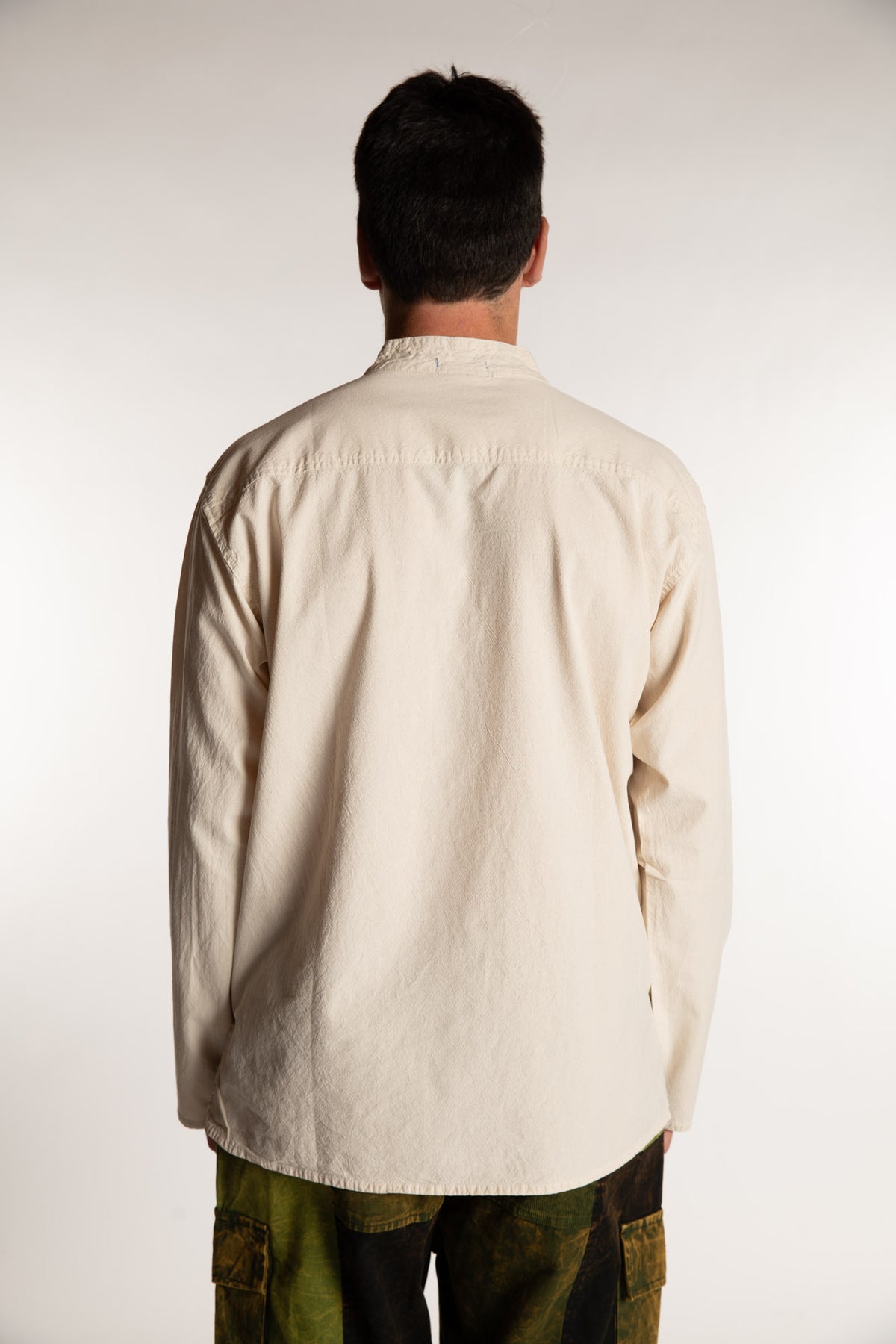 Topher is wearing the Large Arun Band Collar Cotton Shirt in Ivory