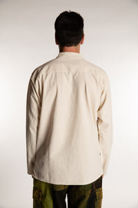 Topher is wearing the Large Arun Band Collar Cotton Shirt in Ivory
