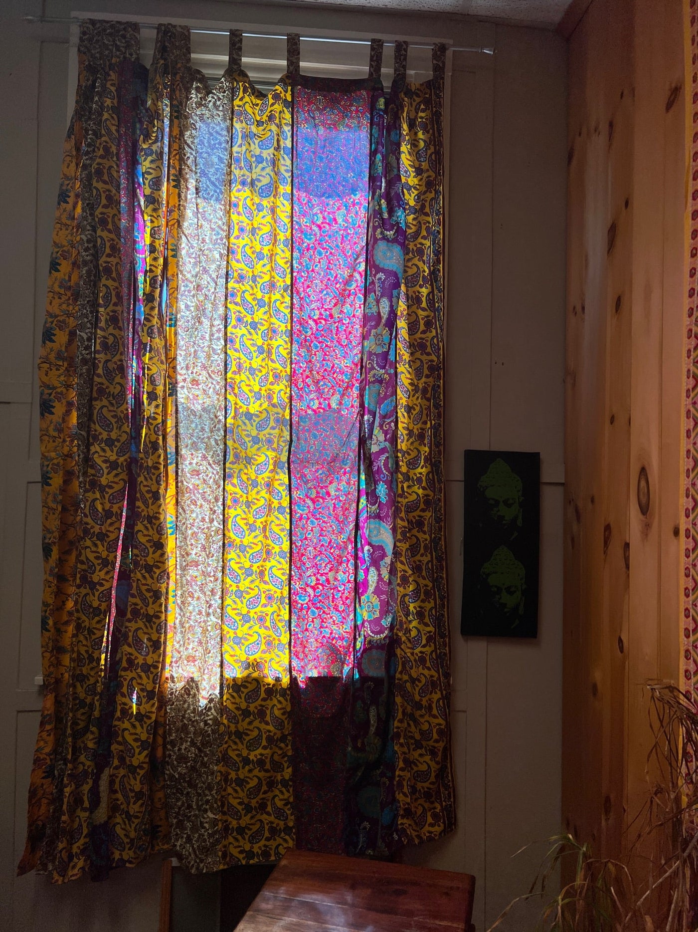 Vibrant curtains with red and yellow panels hanging in front of a window. 