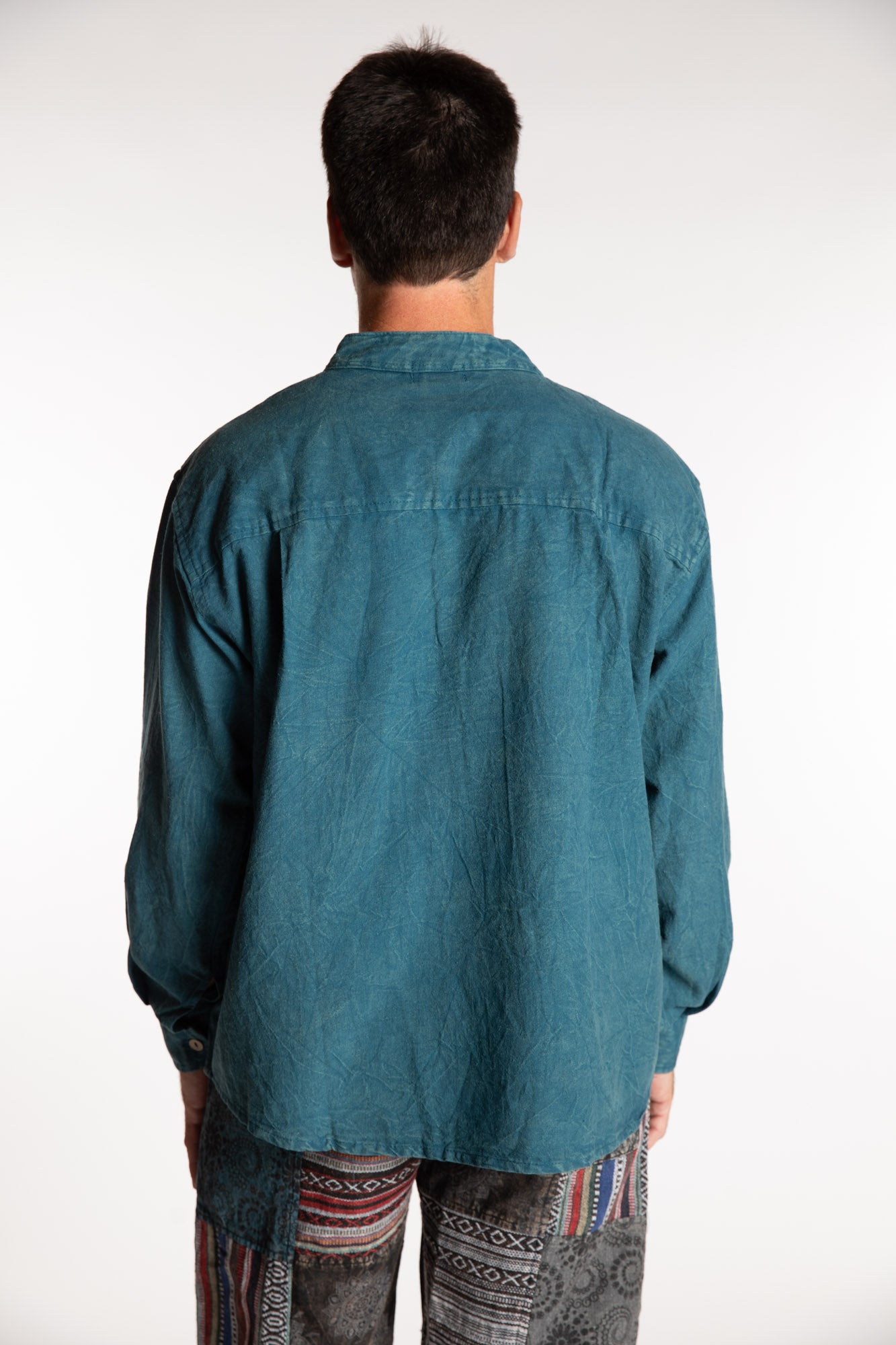 Topher is wearing the Teal Baje Stone Wash Henley Shirt in a Large