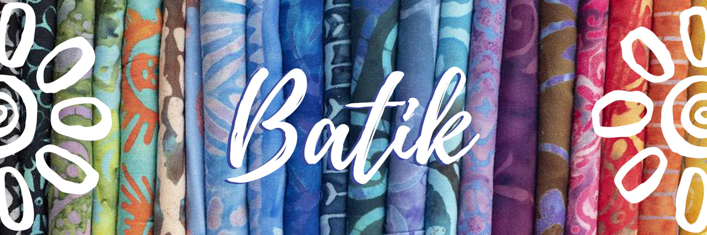 a colorful array of batik fabrics folded to show off a whole spectrum of possibilities with the word batik and two flowers overlaid on the image