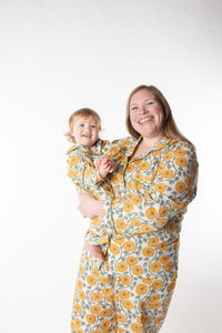 Olivia and Pumpkin standing against a white background, wearing size XL in dandelion, a blue and white floral block print pajama set. 