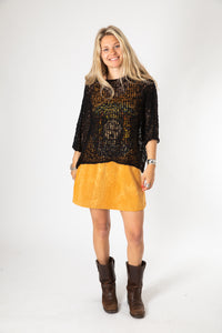 Sophie wearing a black lightweight knitted poncho with a solid pattern.