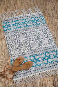 Block print woven rug in natural and teal