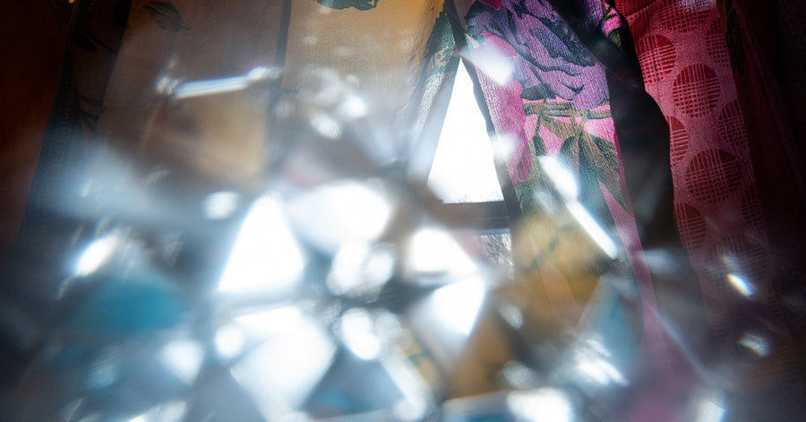 a psychedelic kaleidoscope of colors photographed through a crystal prism with recycled silk panel curtains in a window in the background