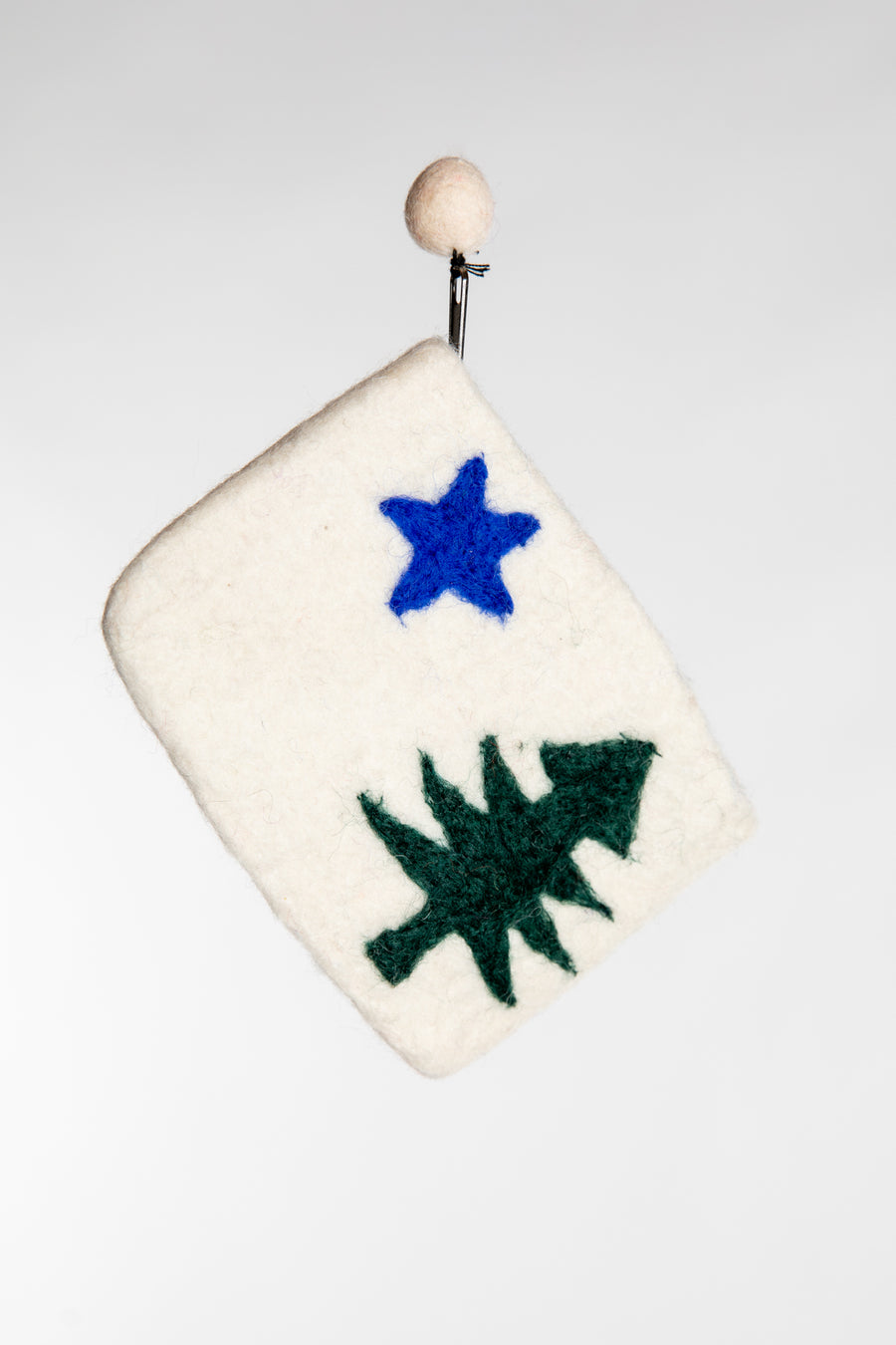 A white felted pouch with a green fir tree and blue star design 