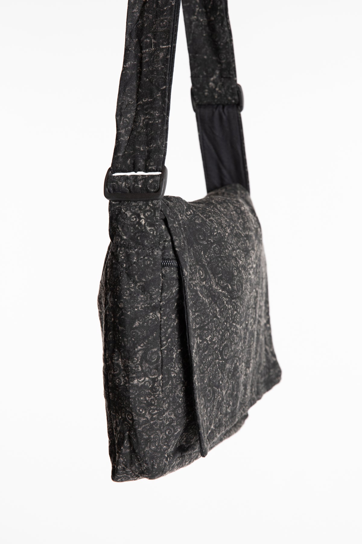 The black ebb and flow messenger bag with a wide adjustable strap