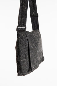 The black ebb and flow messenger bag with a wide adjustable strap