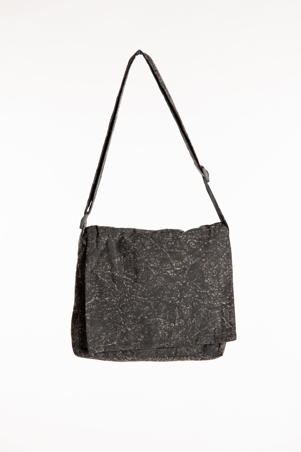 Black cotton messenger bag with foldover flap and adjustable shoulder strap