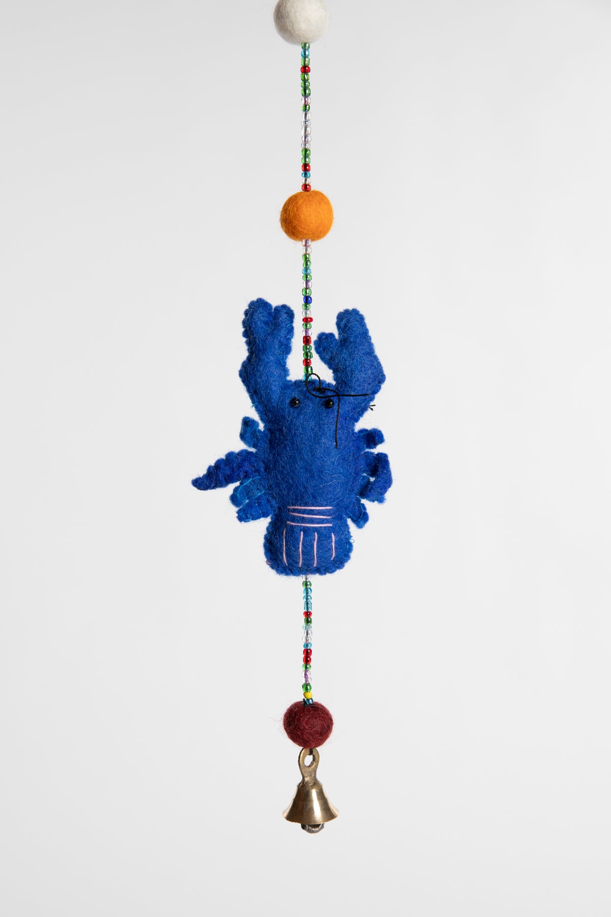 A closeup of a beaded felt blue lobster garland with felt balls 