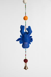 A closeup of a beaded felt blue lobster garland with felt balls 