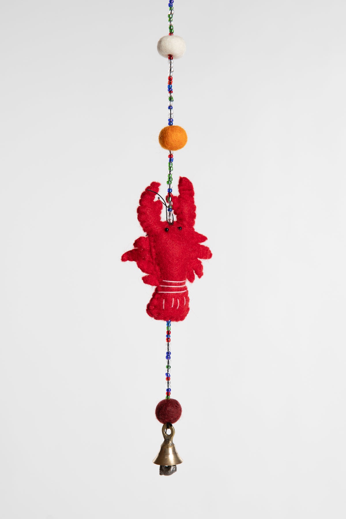 A closeup of a beaded felt red lobster garland with felt balls