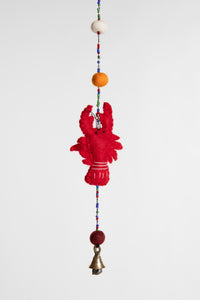 A closeup of a beaded felt red lobster garland with felt balls