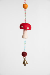 A closeup of the beaded garland with felt balls and red and white felted mushrooms 