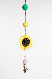 A closeup of the felted sunflower on the beaded garland as well as multicolor felt balls 