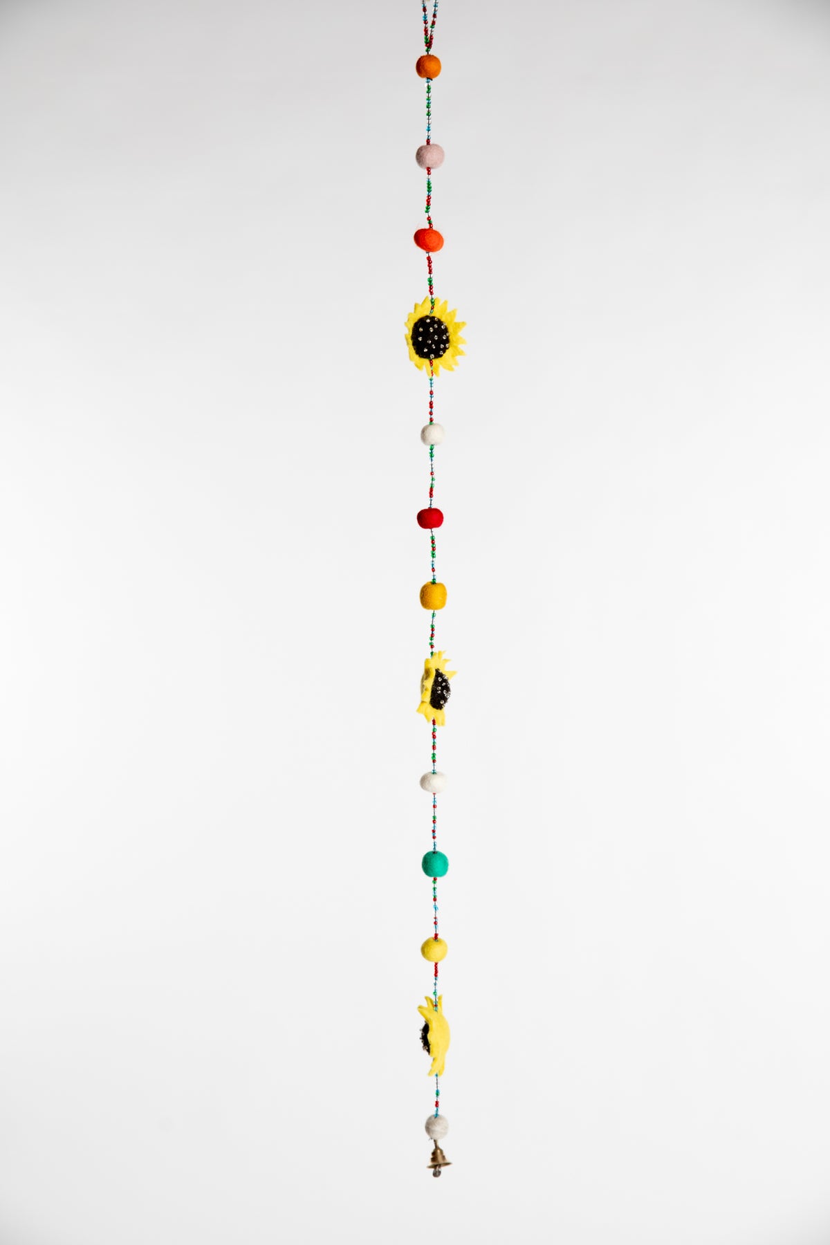 A beaded garland containing felt sunflowers and multicolor felt balls