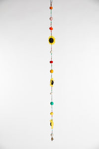 A beaded garland containing felt sunflowers and multicolor felt balls