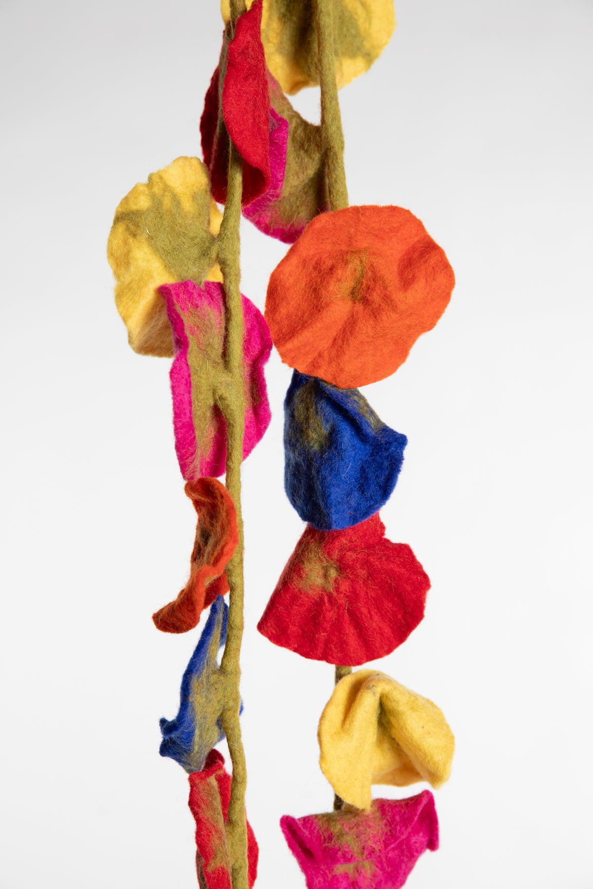 A felted garland of multicolor felt flower shapes