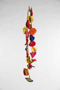 A felted garland of multicolor felt flower shapes 