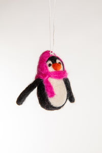 A felted penguin ornament with a pink hat and scarf
