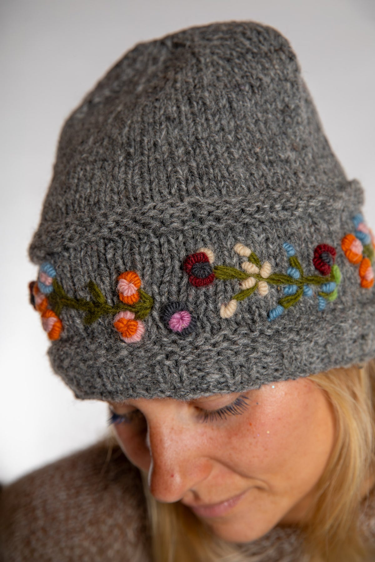 Sophie is wearing the Garden Embroidered Wool Beanie in Gray