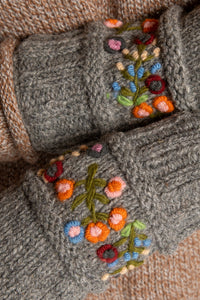 Sophie is wearing the Garden Embroidered Wool Fingerless Mittens in Gray