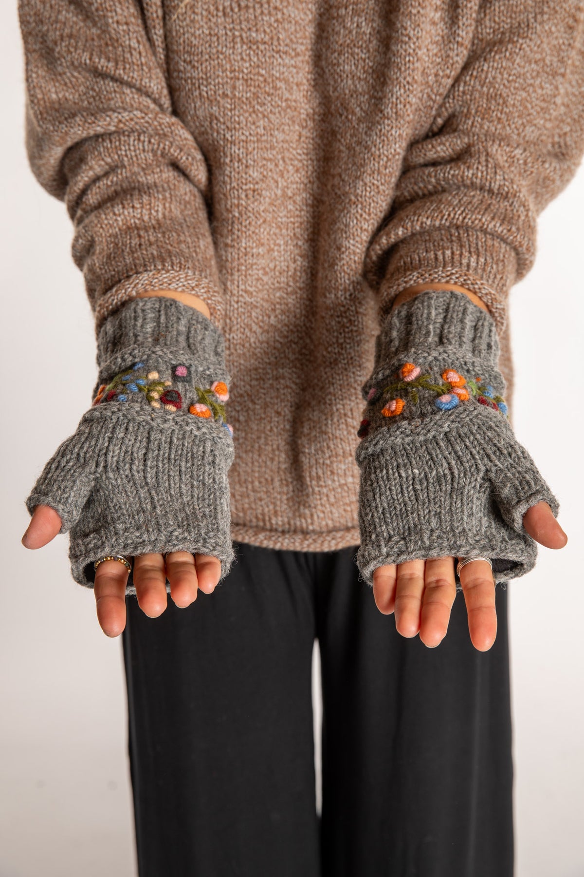 Sophie is wearing the Garden Embroidered Wool Fingerless Mittens in Gray