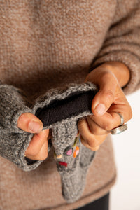 Sophie is wearing the Garden Embroidered Wool Fingerless Mittens in Gray