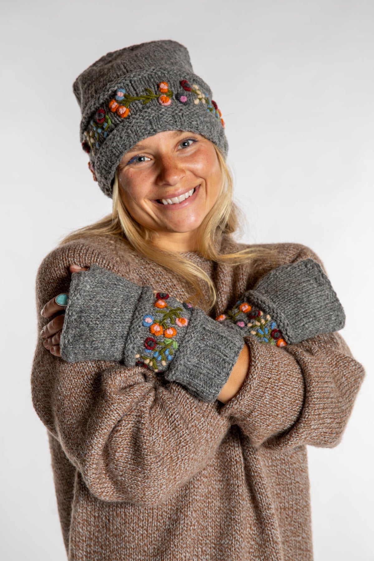 Sophie is wearing the Garden Embroidered Wool Fingerless Mittens in Gray
