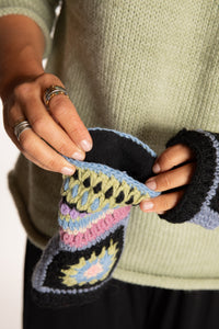 Sophie is wearing the Granny Square Wool Fingerless Mittens in Lavender