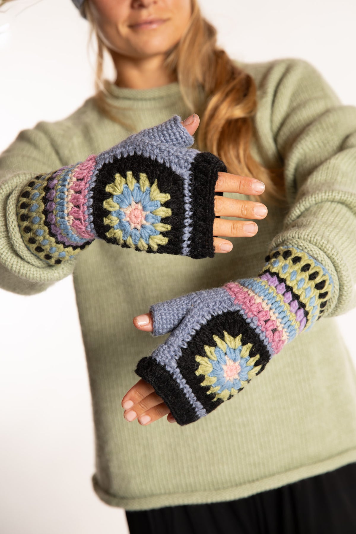 Sophie is wearing the Granny Square Wool Fingerless Mittens in Lavender