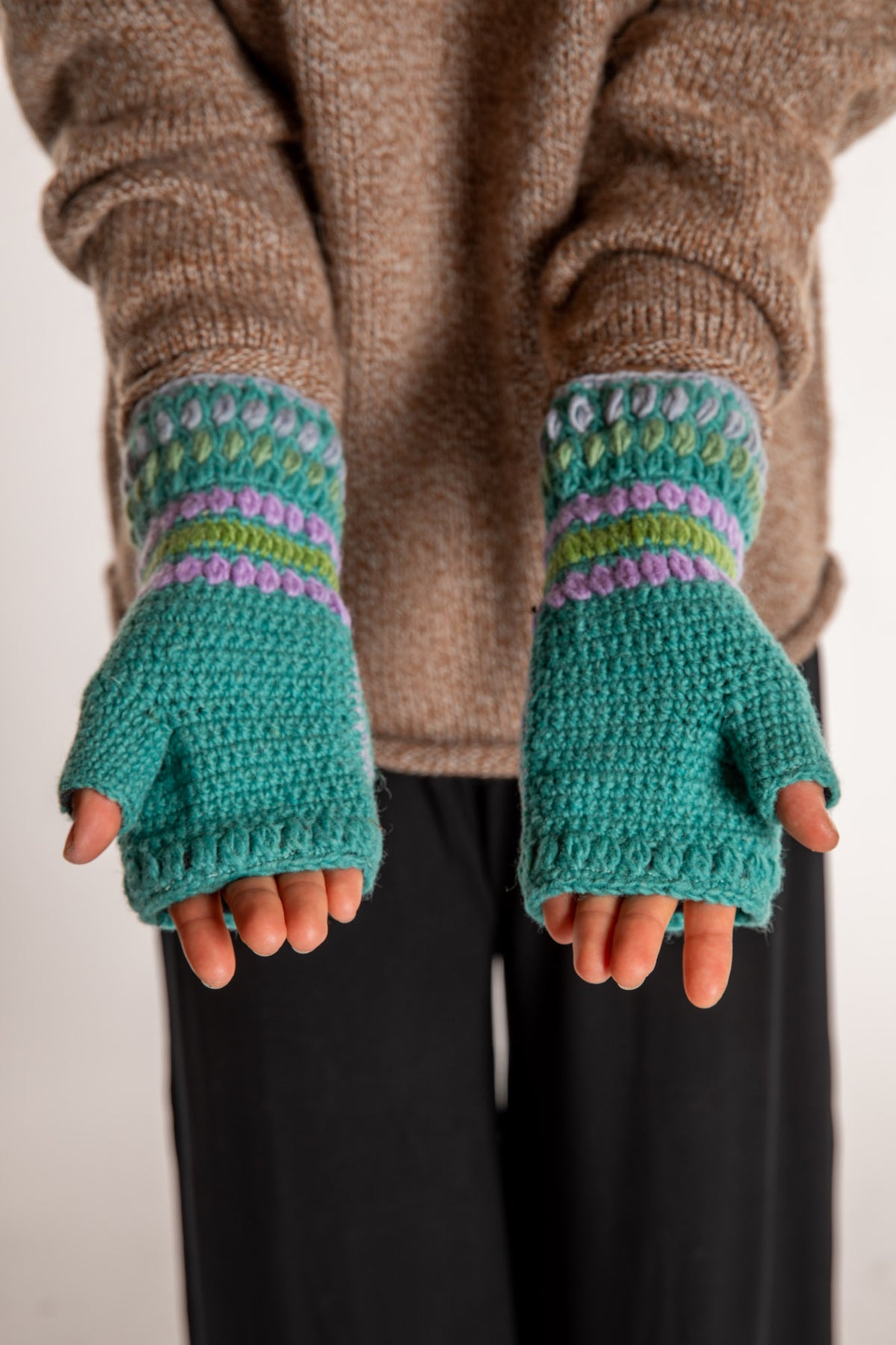 Sophie is wearing the Granny Square Wool Fingerless Mittens in Mint